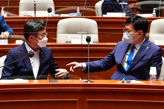 송영길 민주당 대표(오른쪽)와 윤호중 민주당 원내대표가 지난 18일 국회에서 열린 부동산 정책의원총회에서 대화를 나누고 있다. 연합뉴스